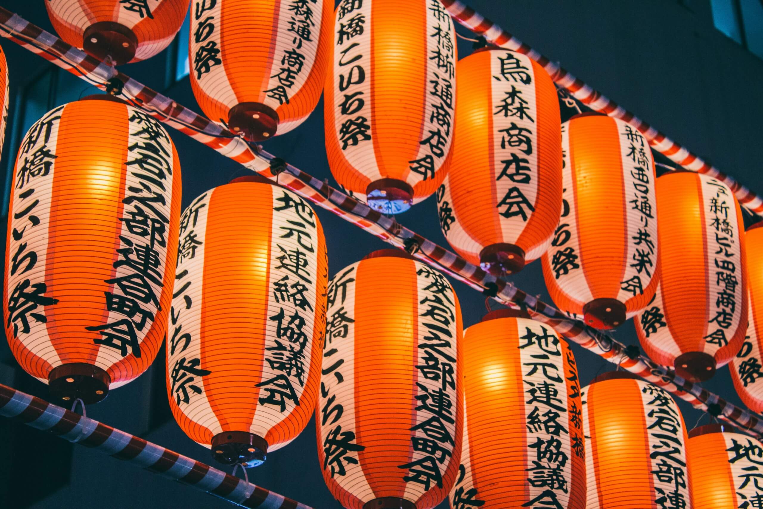 Glowing orange paper lanterns, show the atmosphere of the Obon festival.